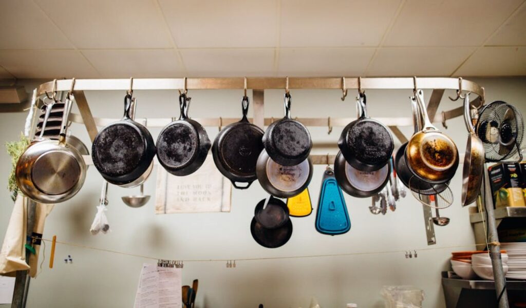 Assorted Frying Pans Hanging on Pot Rack