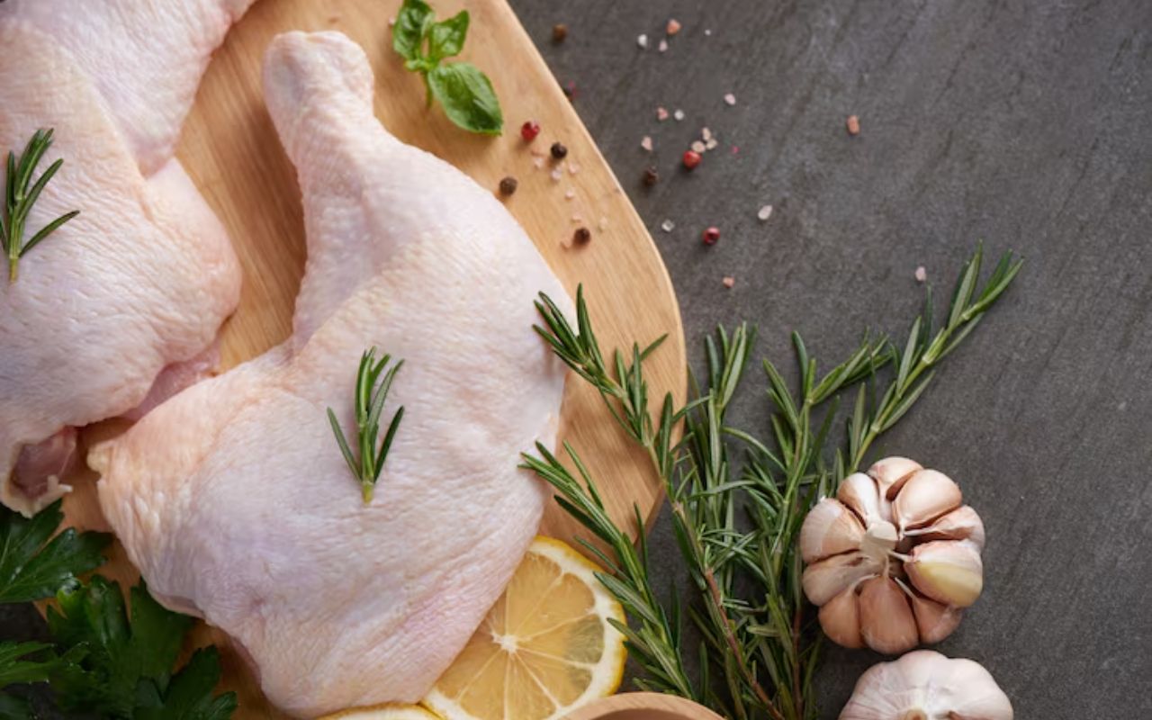 Raw bone-in chicken thighs with lemon, garlic, and herbs