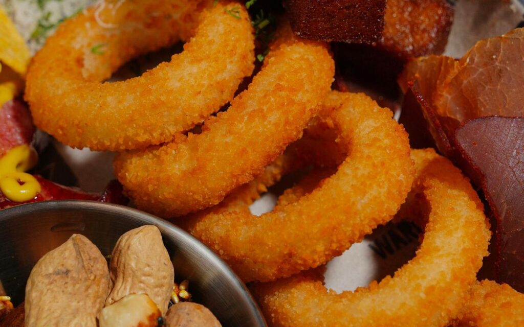 Crispy onion rings with peanuts and cured meat