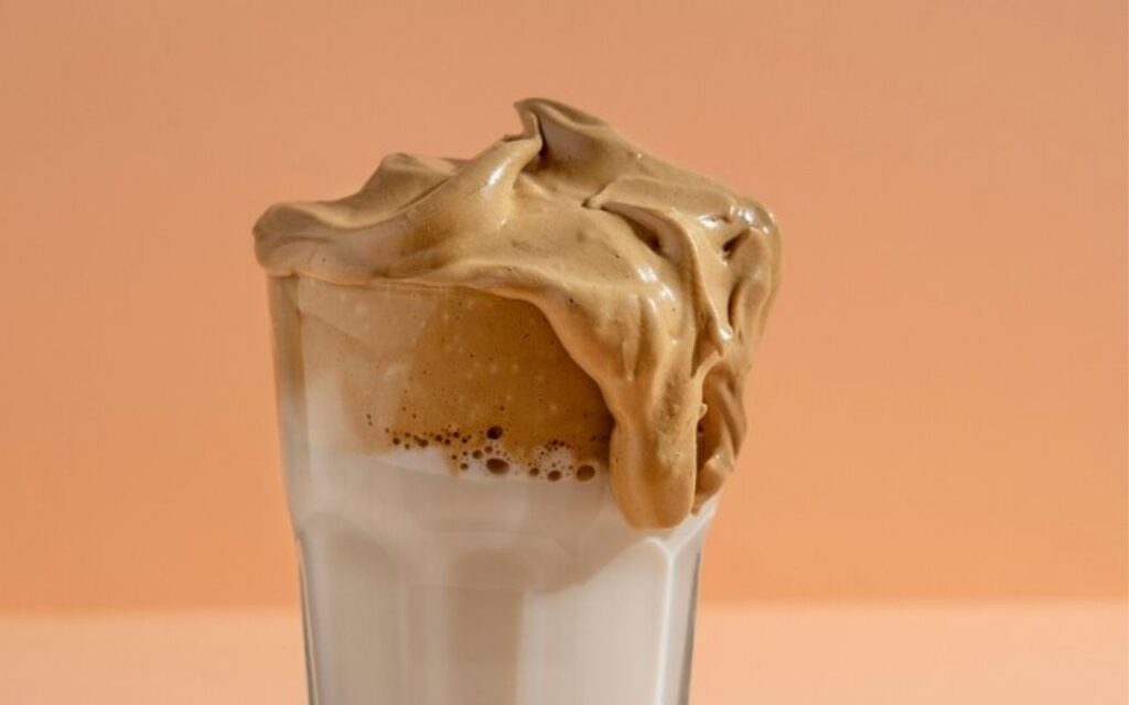 Glass of dalgona coffee with frothy whipped top