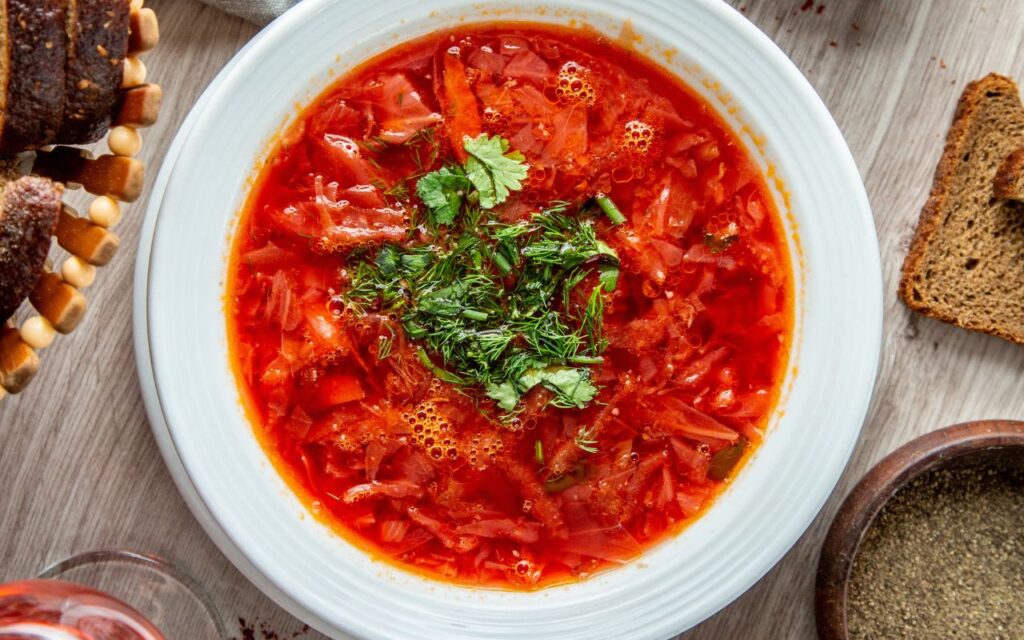 Bowl of chicken paprikash soup garnished with fresh herbs