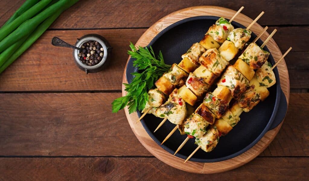 Chicken skewers with slices of apples and chili. top view