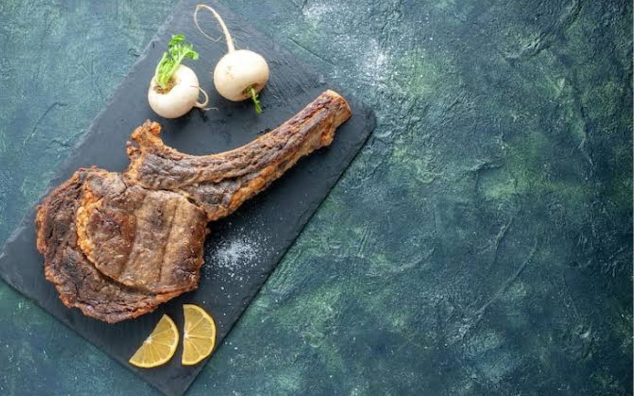 Tomahawk steak with turnips and lemon wedges