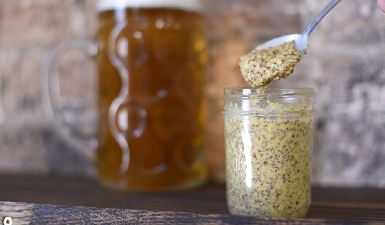 Clear glass jar filled with mustard