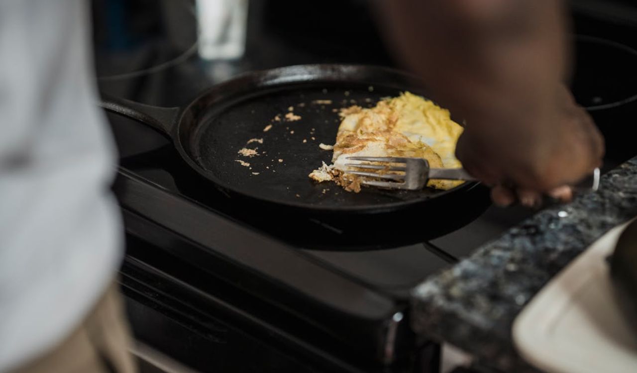 Close-up of man getting food in cast iron