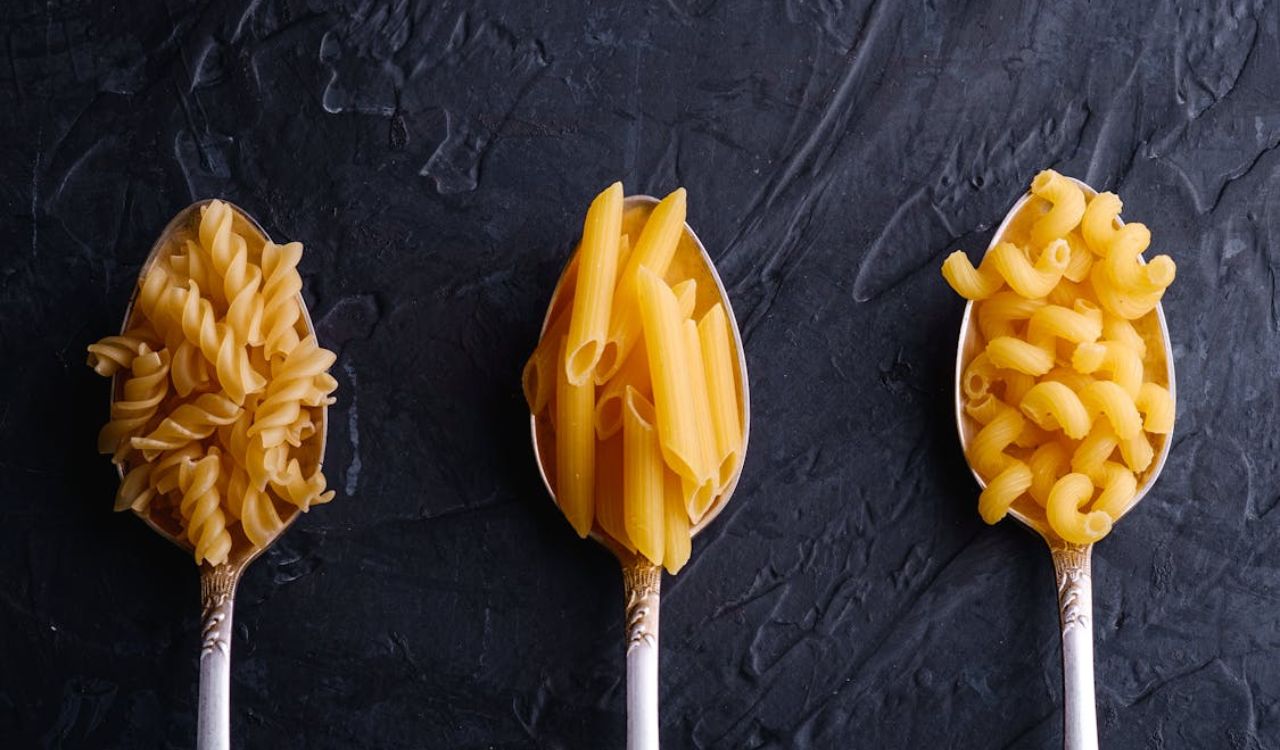 Different kinds of pasta on spoons