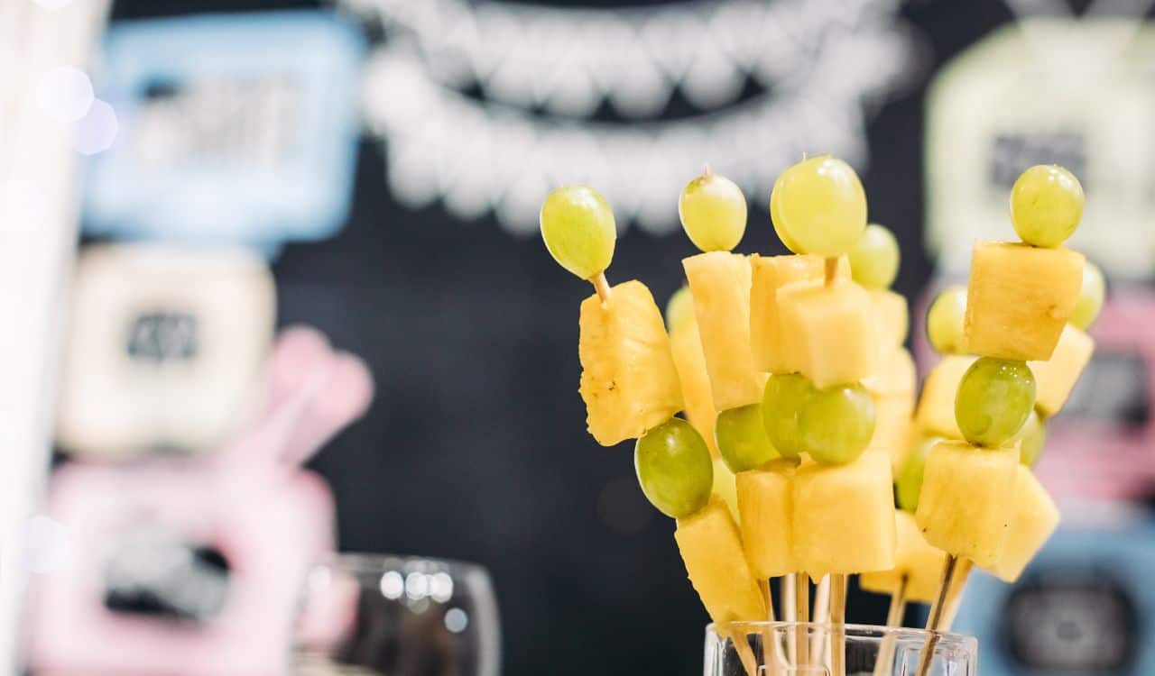 Tasty canapes with cheese and green grapes in glass