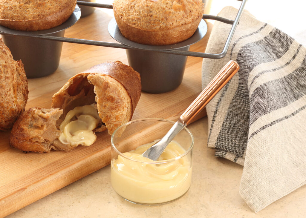 Hot popovers split open with butter and honey on the side.