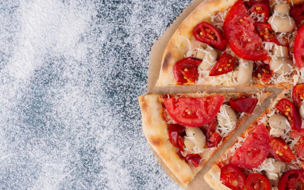 Tomato-topped pizza slices on a floured surface