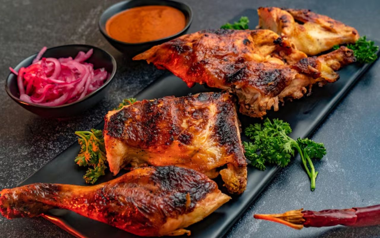 Grilled jerk chicken with sauce and pickled onions
