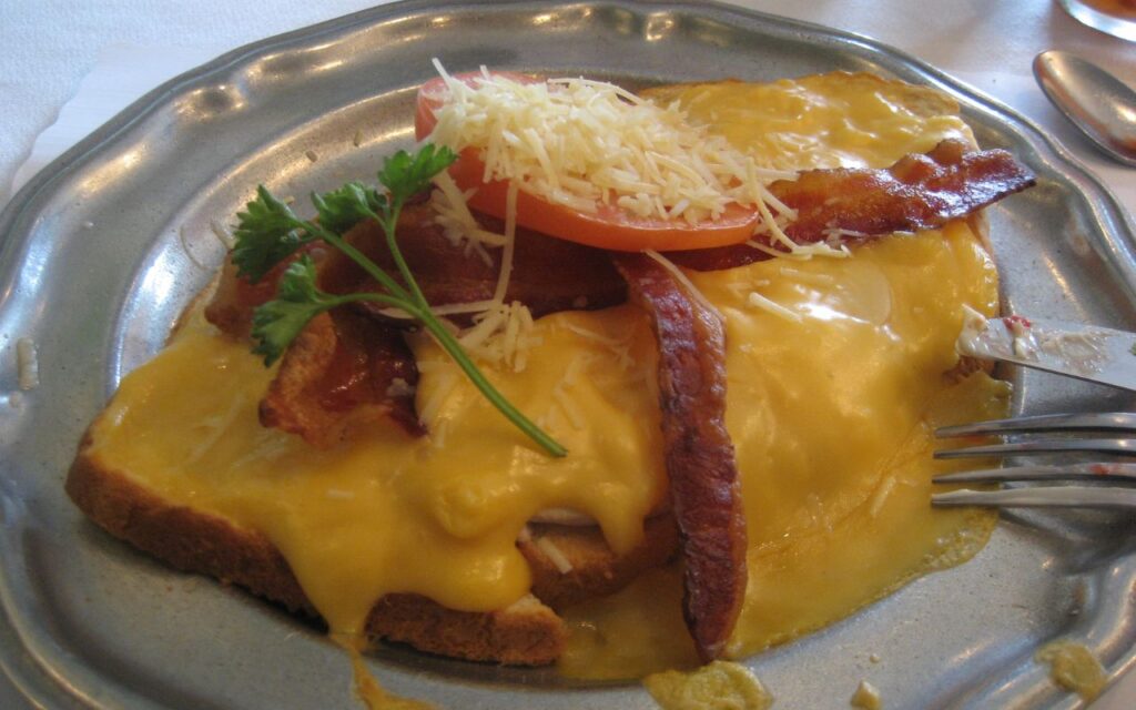 Hot Brown sandwich with bacon, tomato, and melted cheese