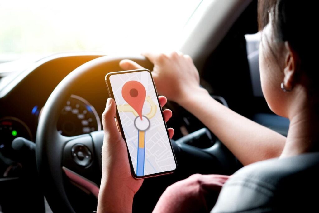 A woman car driving on the road And she is looking for a GPS map on a smartphone to get to the destination of the route.