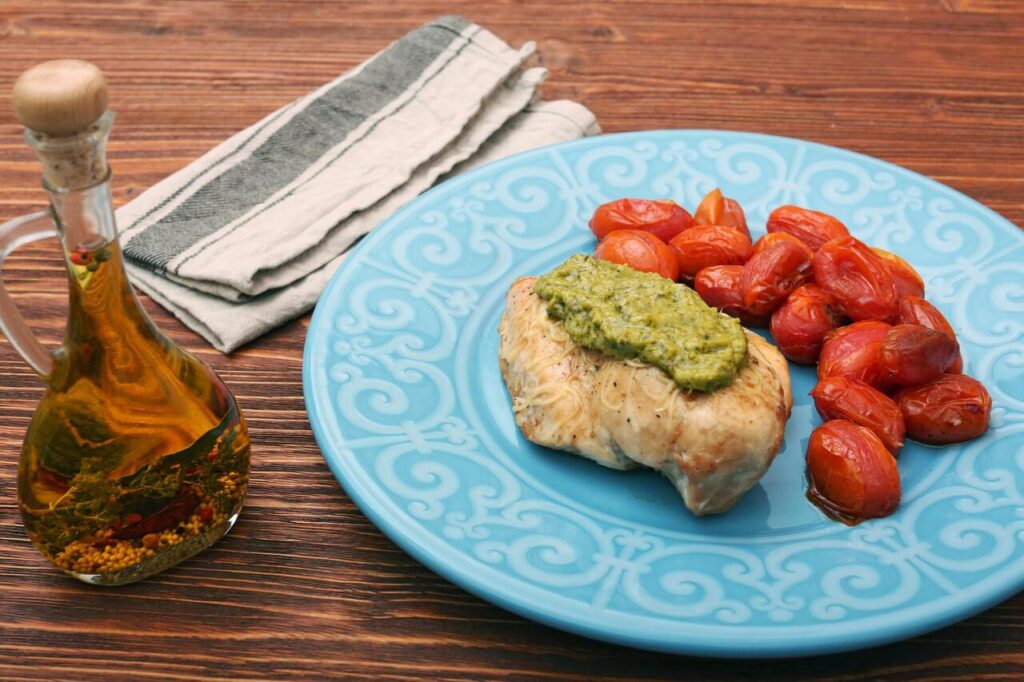tasty baked chicken breasts covered with basil pesto sauce