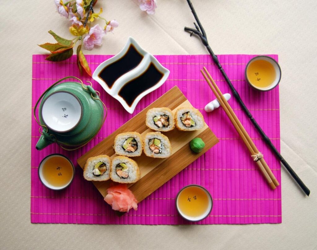 A Japanese dining setting with sushi rolls on one plate and sashimi elegantly displayed on another.