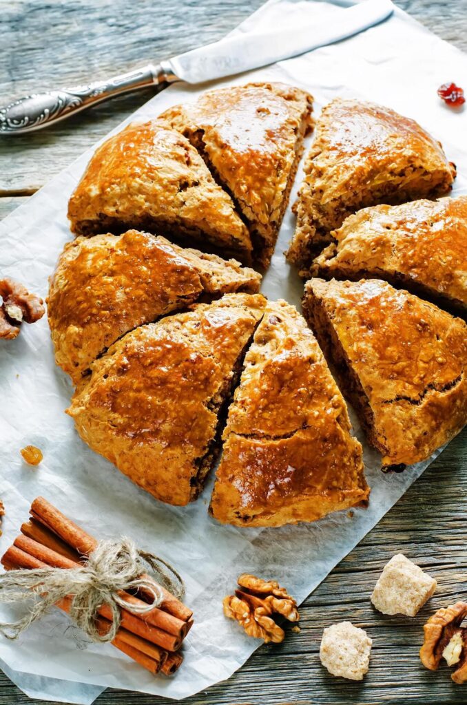pumpkin scones with cinnamon, raisins and walnuts on a dark wood background. tinting. selective focus