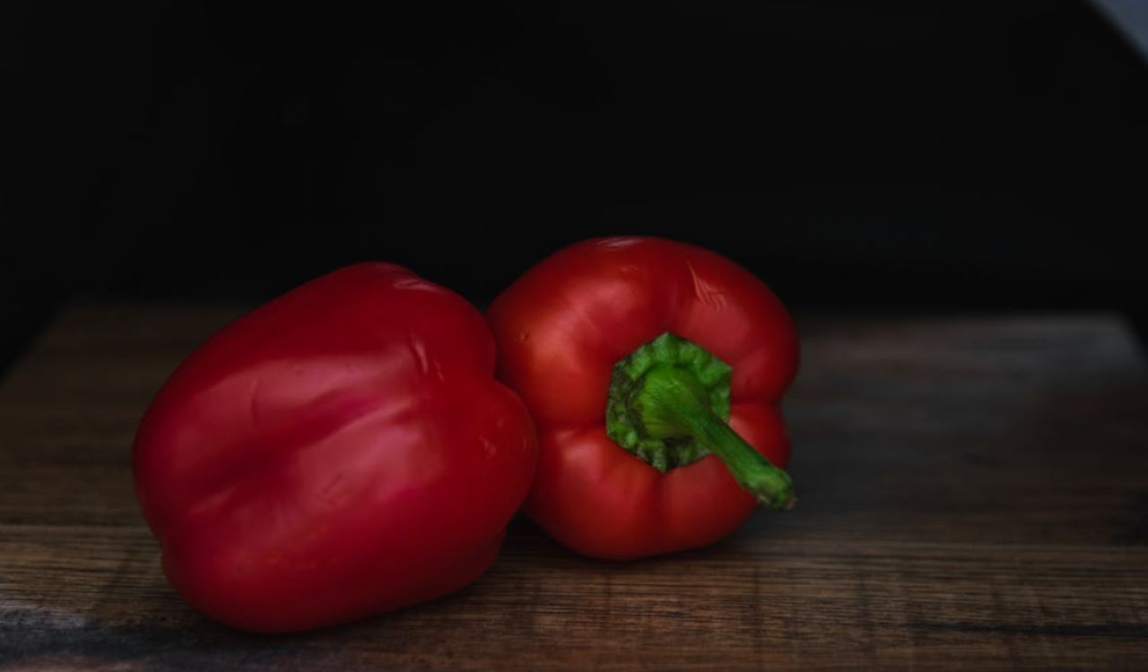 Tasty fresh red sweet bell peppers on table