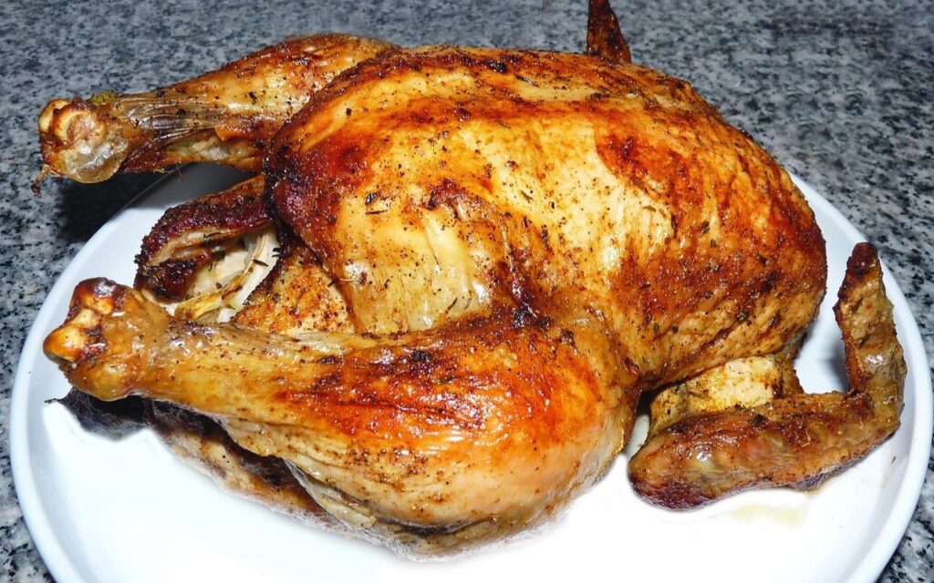 Whole roasted rotisserie chicken with golden, crispy skin
