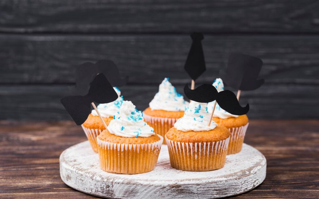 Vanilla cupcakes with whipped topping and decorative toppers