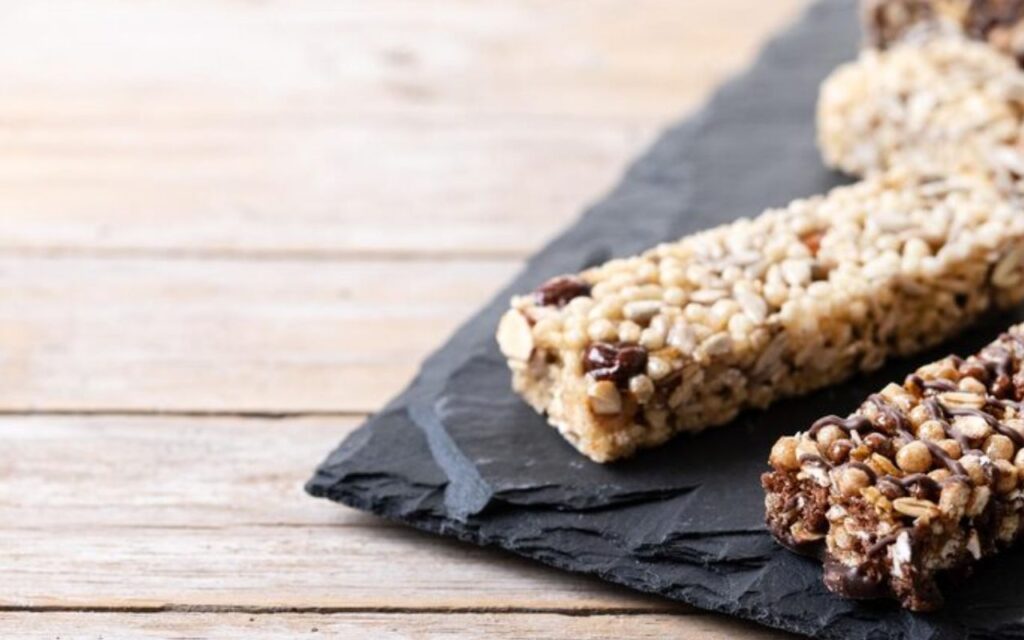 Granola bars with chocolate and nuts on a slate board