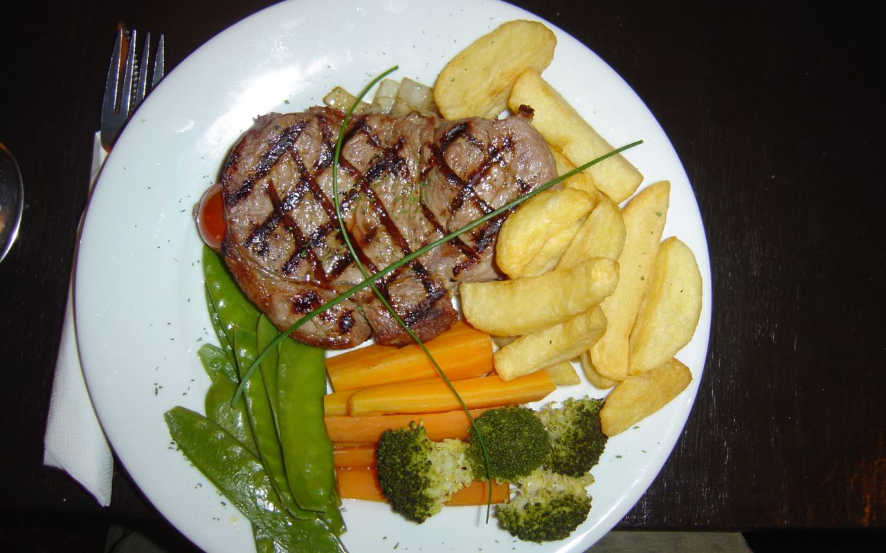 Grilled sirloin steak with fries and vegetables