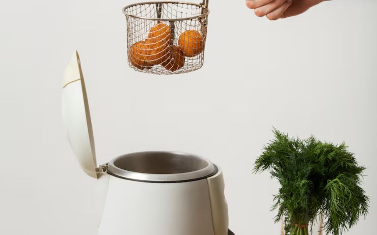Deep fryer basket with fried balls over a cooker