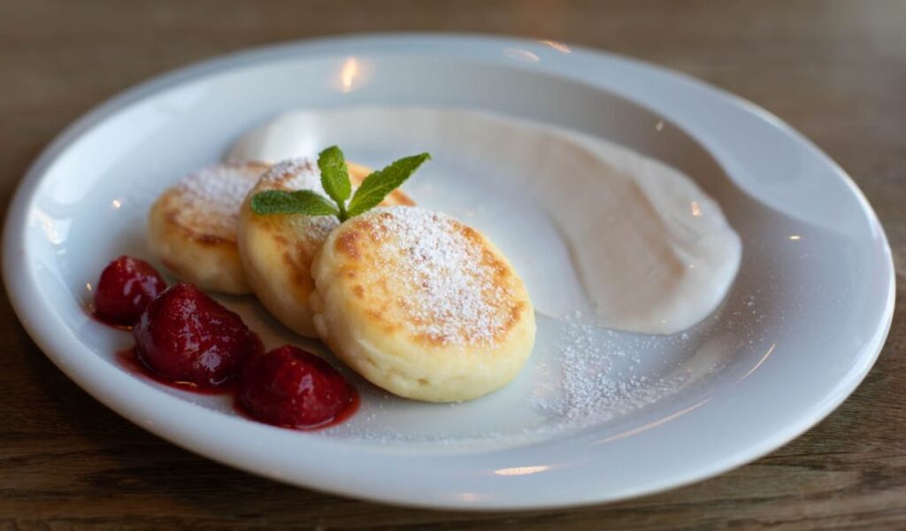 Tasty cottage cheese pancakes with strawberries and sour cream sauce