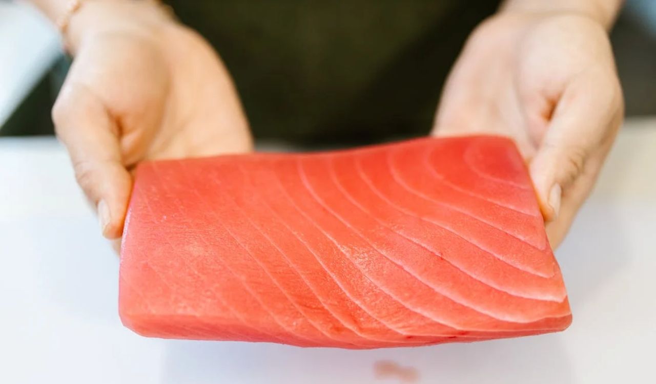 Woman holding slice of salmon