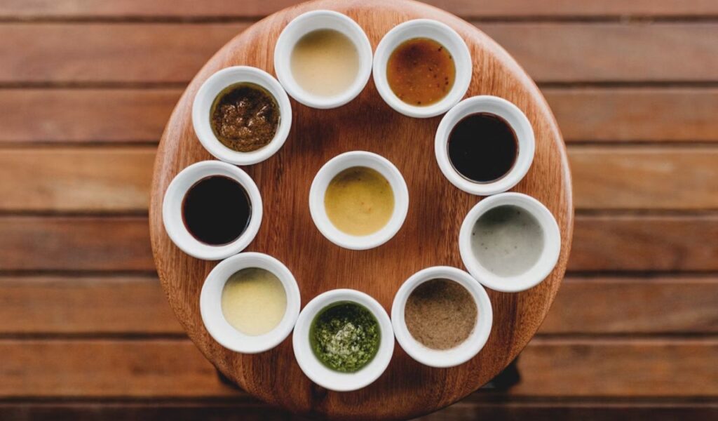 Wooden turntable topped with white cups filled with sauces