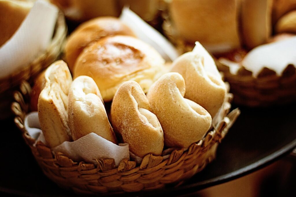 Fluffy Parker House rolls in a basket, ready to eat.