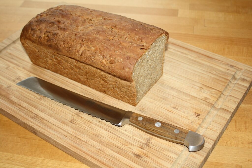 Unsliced loaf placed cut side down on a wooden board.
