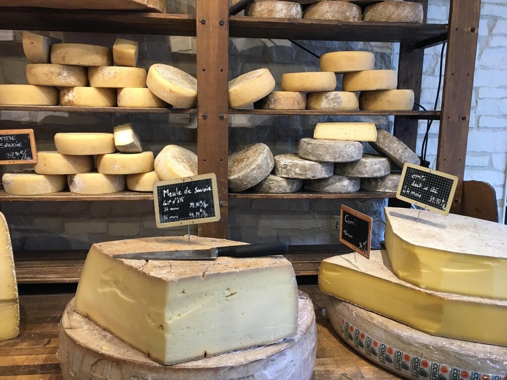 small rounds of Munster arranged on shelves, showcasing its artisanal production.