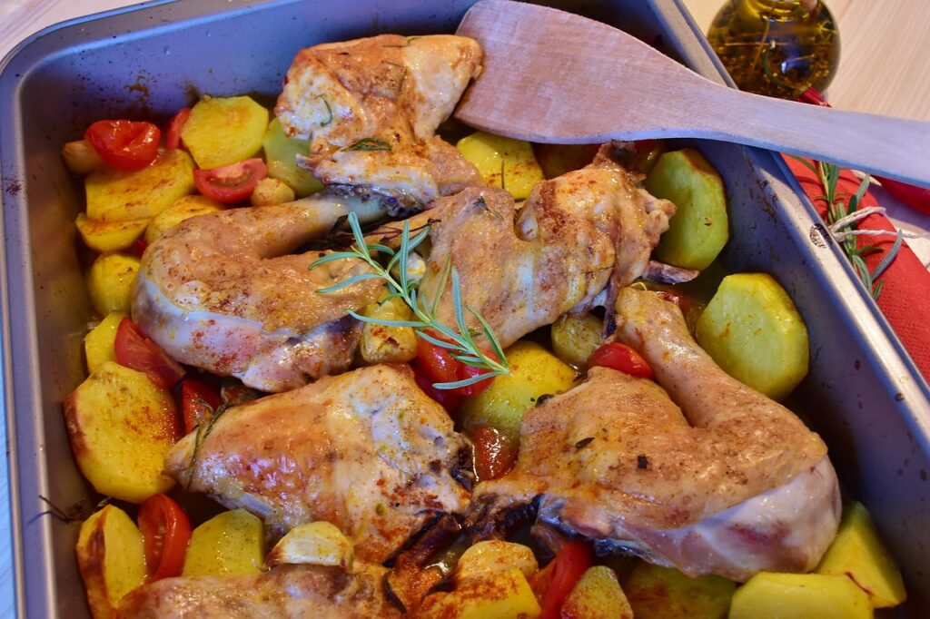 Sheet pan with lemon garlic chicken and veggies, garnished with fresh herbs.