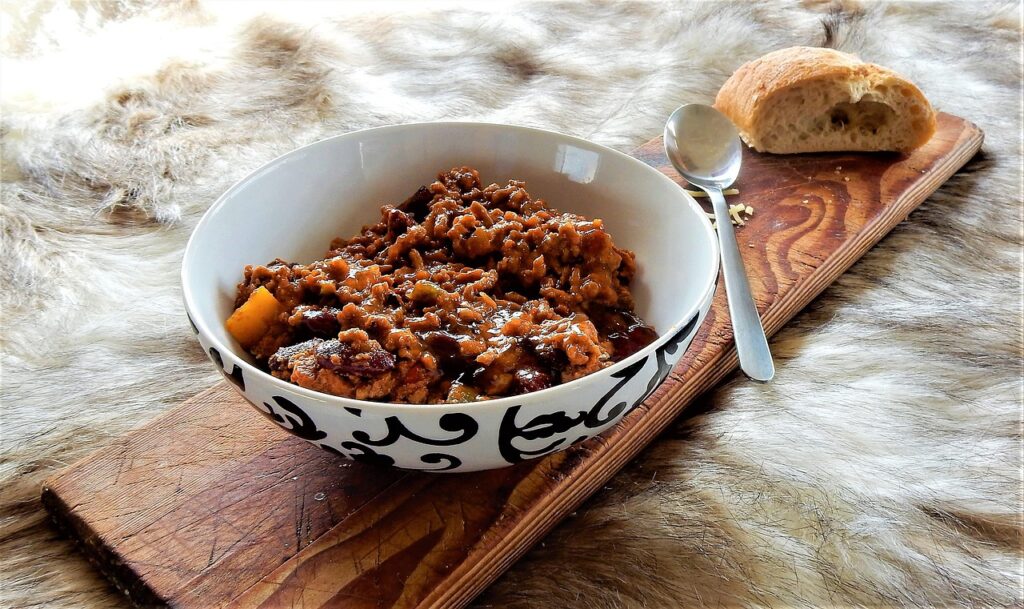 Bowl of steaming chili with cornbread.