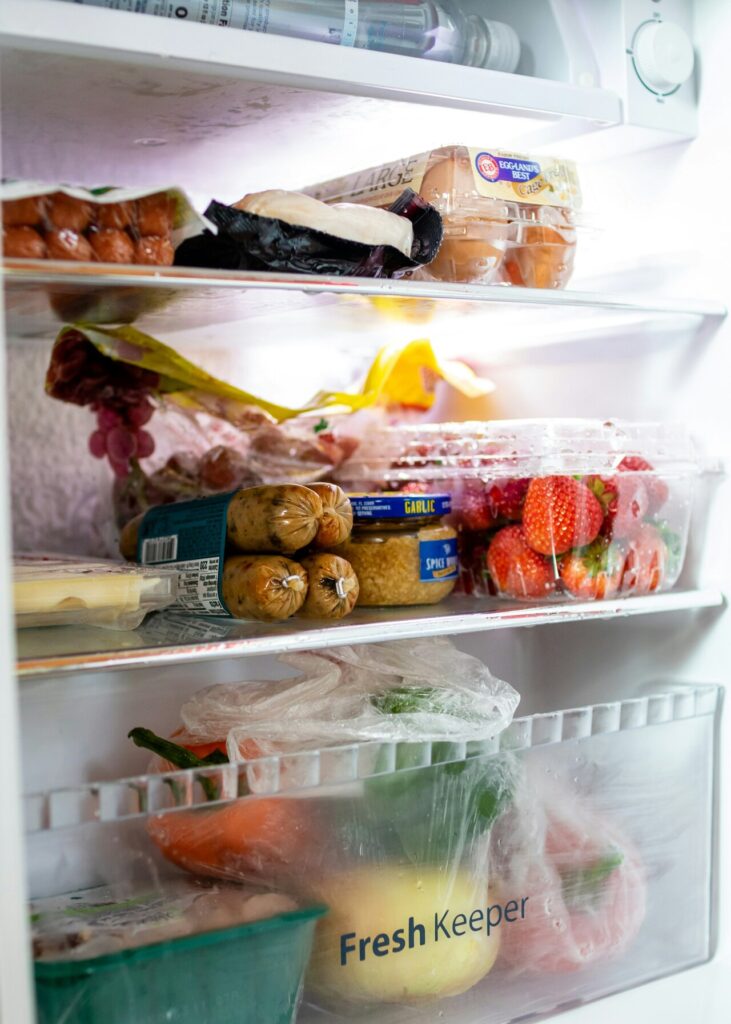 Fridge shelves organized with clear bins and containers.