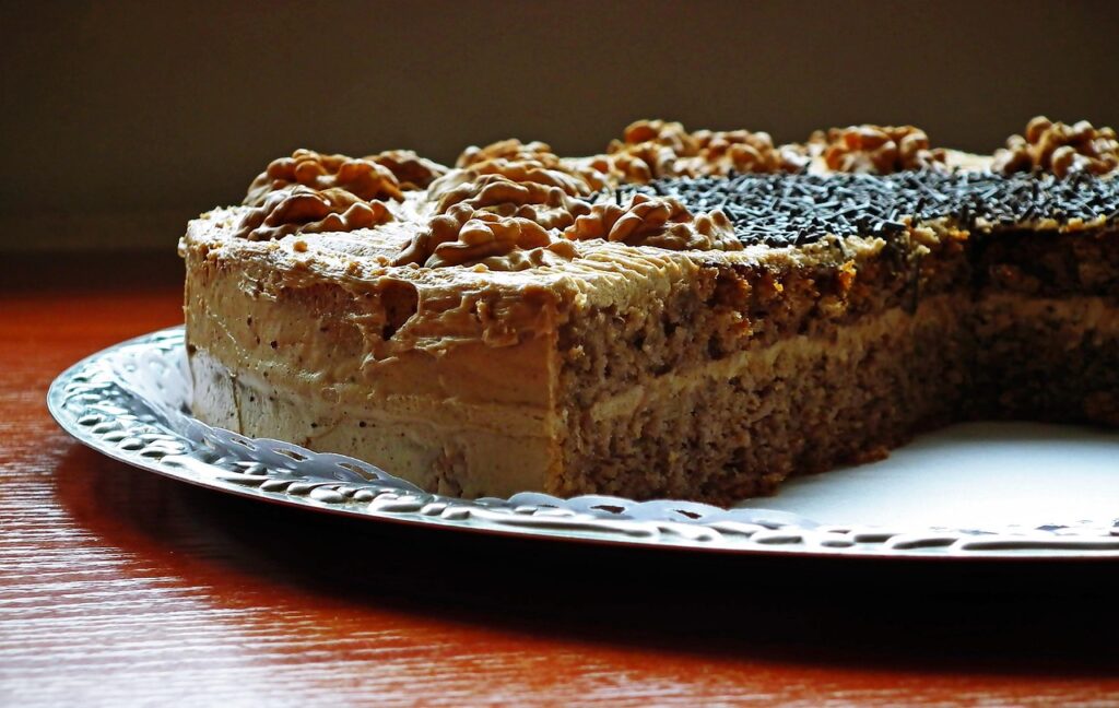 Spiced cake with cream cheese frosting and chopped nuts.