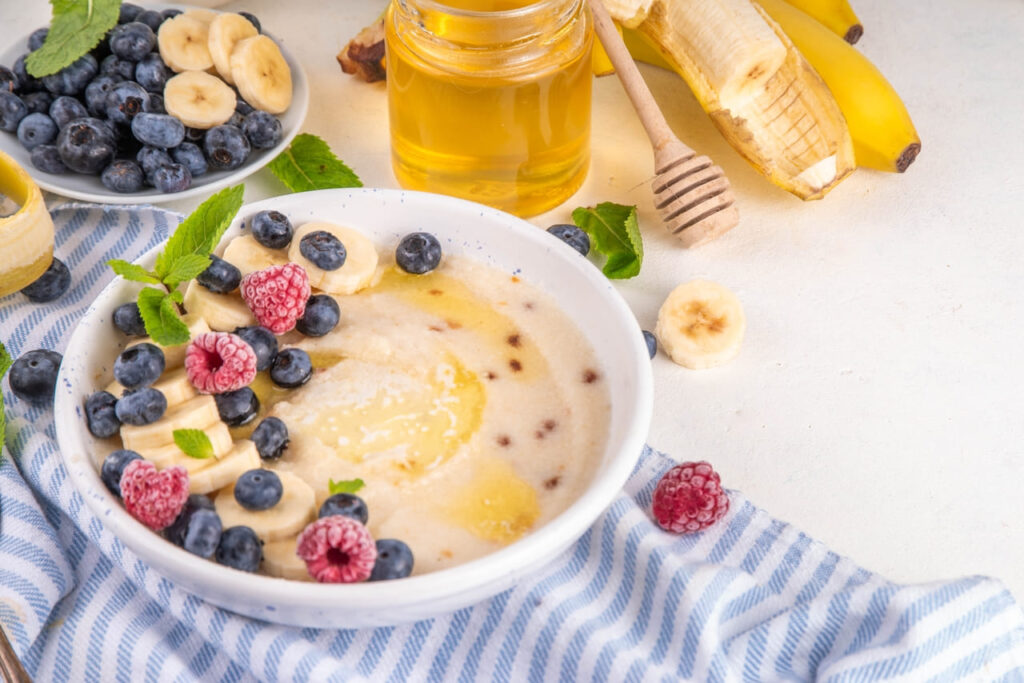 Sweet breakfast farina porridge with butter, honey and fruits. American creamy milled wheat flour porridge, hot breakfast cereal