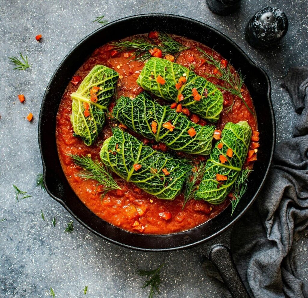 tomato sauce simmering in a pan with carrots, zucchini, and spinach being blended in.