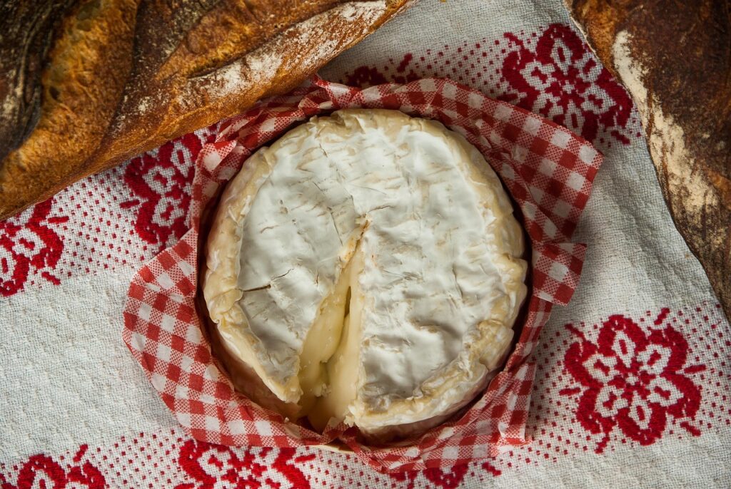 Traditional Camembert de Normandie in rustic surroundings with cider.