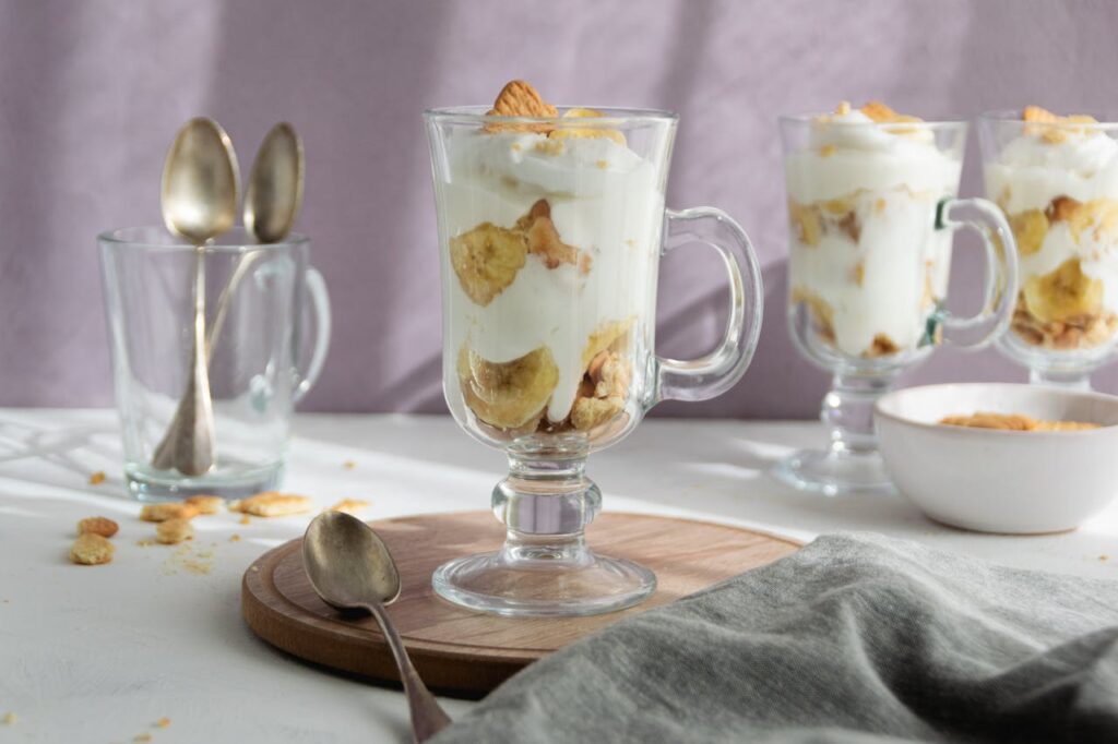 A glass trifle dish layered with banana pudding components.