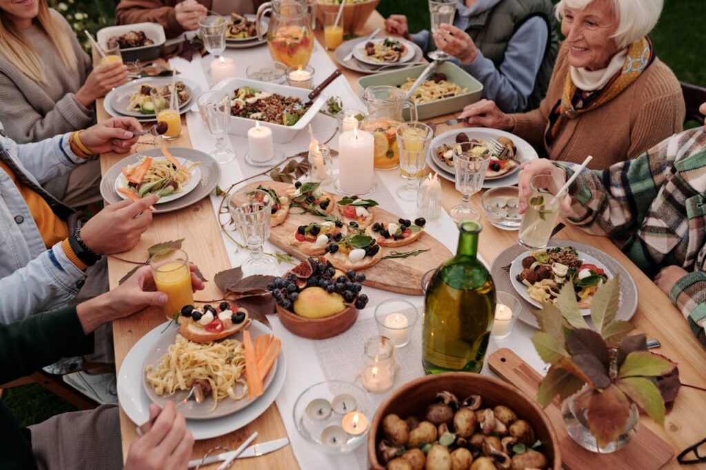 Family sitting together at a rustic kitchen table with food in the center.