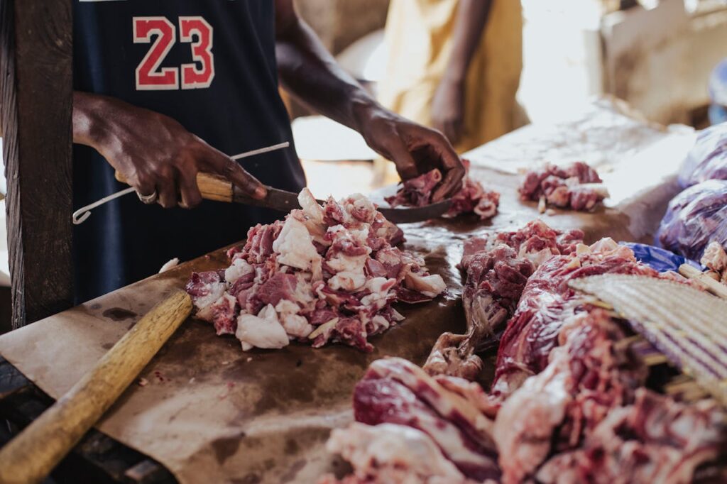 Butcher Preparing Fresh Meat at Market Table
