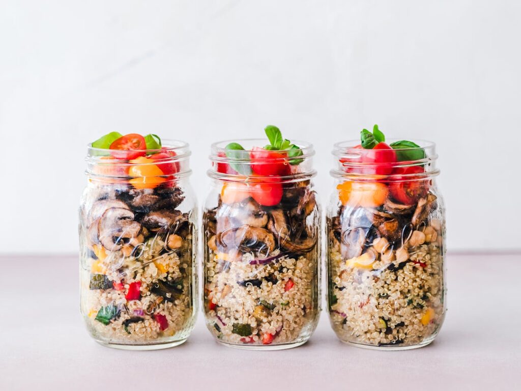 Quinoa salad in a clear container with colorful vegetables