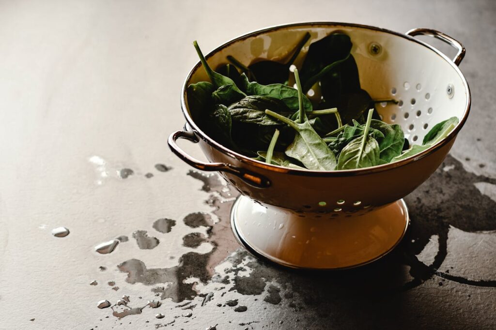 Large tub of baby spinach on a kitchen counter