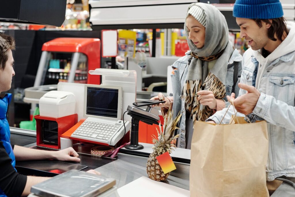 Loyalty card sign-up stand and digital coupon advertising near the checkout.


