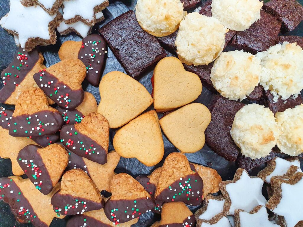 plate of assorted cookies, showcasing a colorful variety with sprinkles, chocolate chunks, and fruit bits.