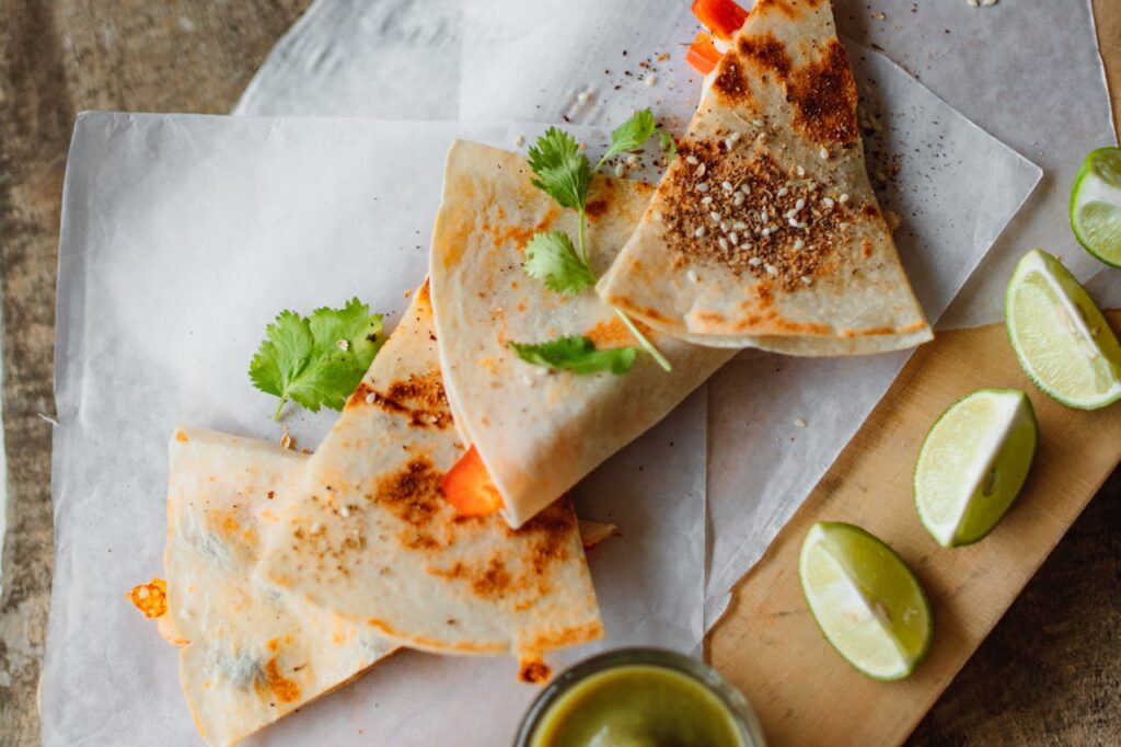 Sliced quesadillas with melted cheese and salsa on the side.