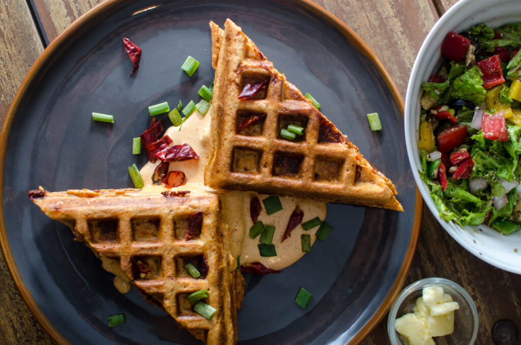 a grilled waffle sandwich. Melted cheese is oozing out. 