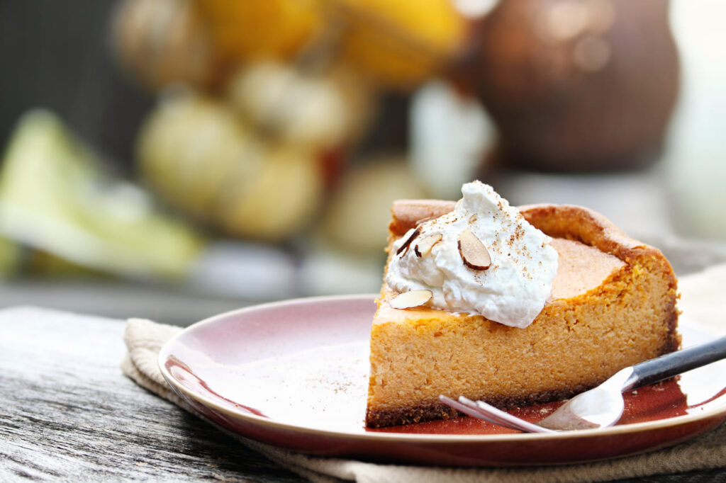 Pumpkin cheesecake slice on a dessert plate with fork