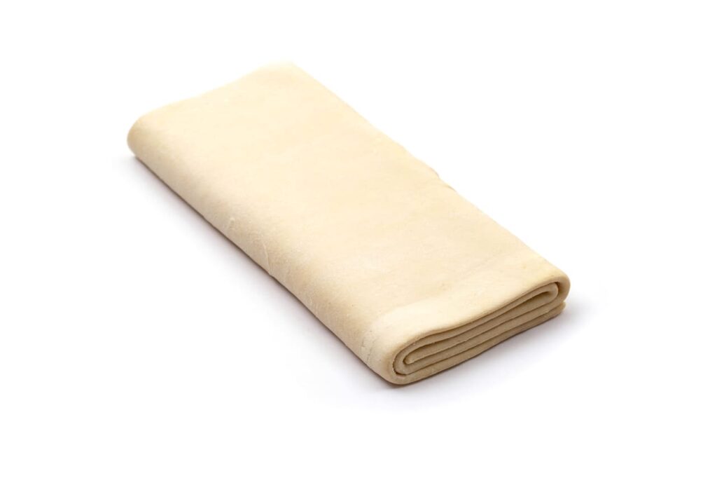 puff frozen dough for baking on a white background, isolate. Close-up