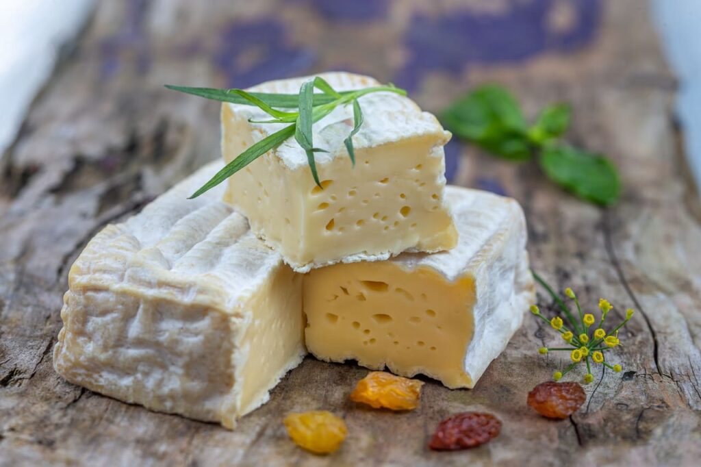 Close up of a Pont l'Eveque (French cheese) alone on old wooden board